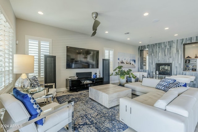 living room with ceiling fan and a large fireplace