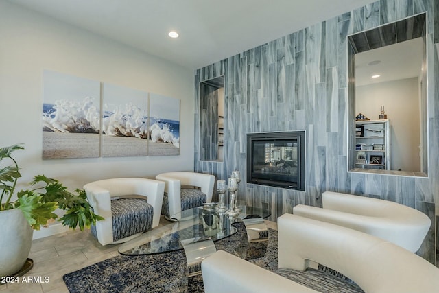 sitting room featuring a multi sided fireplace and tile walls