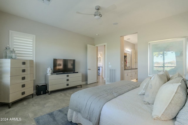 tiled bedroom featuring connected bathroom and ceiling fan