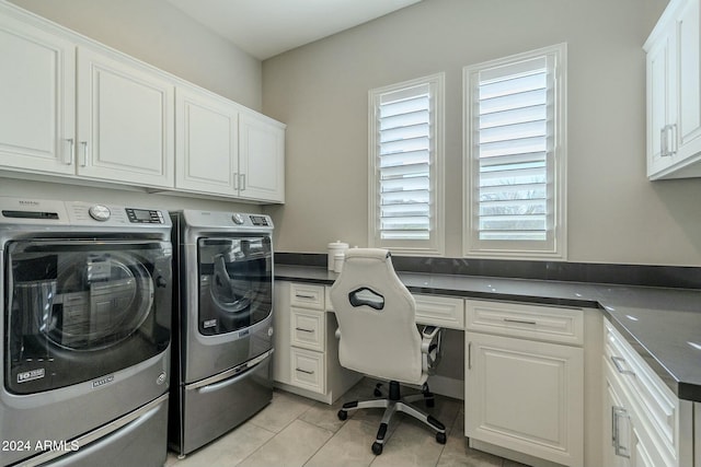 laundry area featuring washing machine and dryer, light tile patterned floors, and cabinets