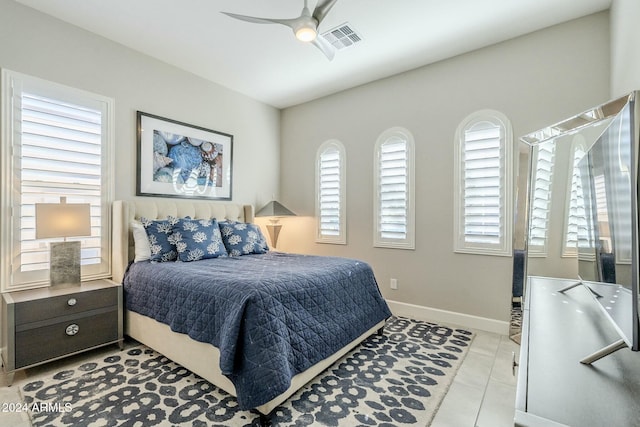 bedroom with ceiling fan, light tile patterned floors, and multiple windows