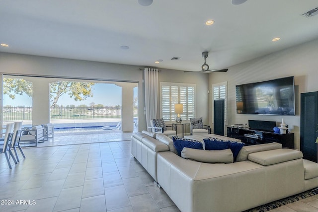 living room featuring light tile patterned floors and ceiling fan