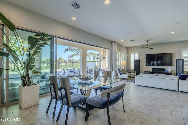 tiled dining space featuring ceiling fan and a healthy amount of sunlight