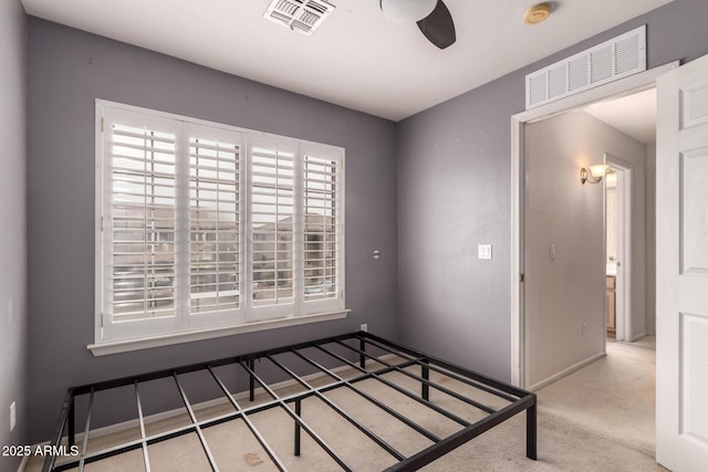 unfurnished bedroom with ceiling fan and light colored carpet