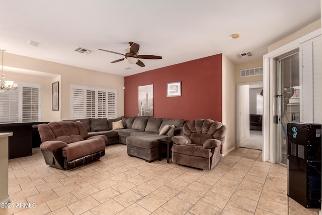 tiled living room with ceiling fan with notable chandelier and wine cooler