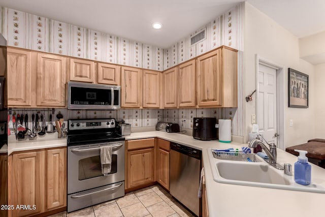 kitchen featuring sink, light brown cabinets, stainless steel appliances, and light tile patterned flooring