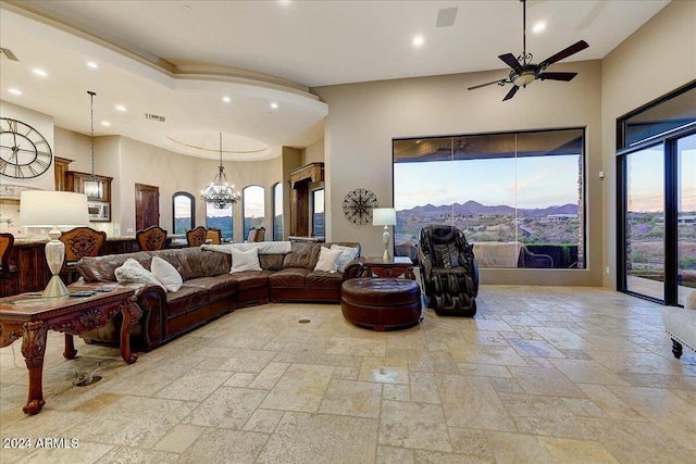 living room with ceiling fan with notable chandelier and a mountain view