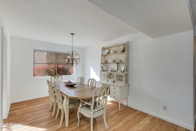 dining area with an inviting chandelier and light hardwood / wood-style flooring