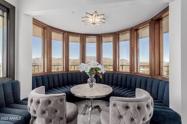 sunroom with a mountain view, a healthy amount of sunlight, and breakfast area