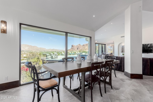 dining room with lofted ceiling and a mountain view