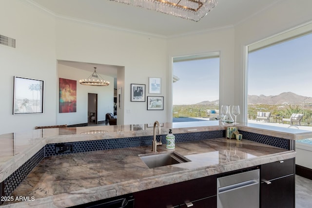 kitchen with decorative light fixtures, sink, crown molding, a mountain view, and an inviting chandelier