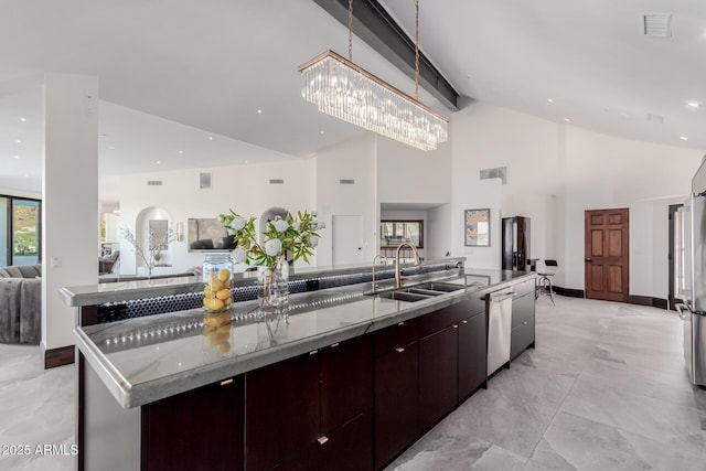 kitchen featuring sink, dishwasher, high vaulted ceiling, dark brown cabinetry, and a large island with sink