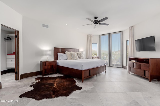 bedroom featuring access to exterior, expansive windows, and ceiling fan