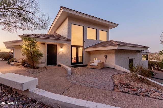 back house at dusk with a patio