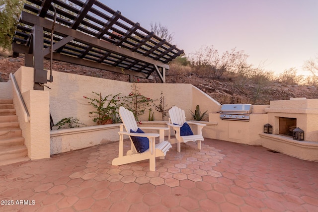 patio terrace at dusk with area for grilling and exterior kitchen