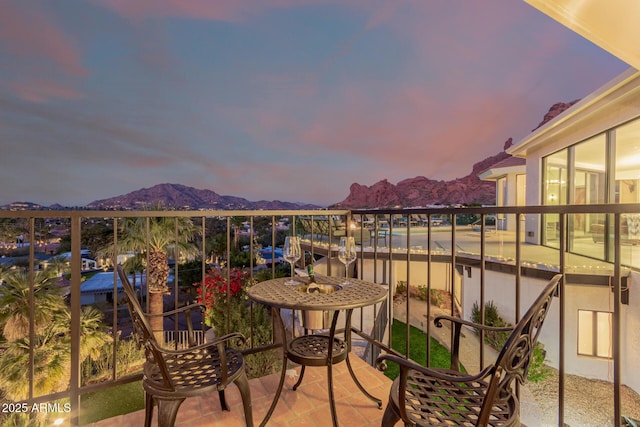 balcony at dusk featuring a mountain view