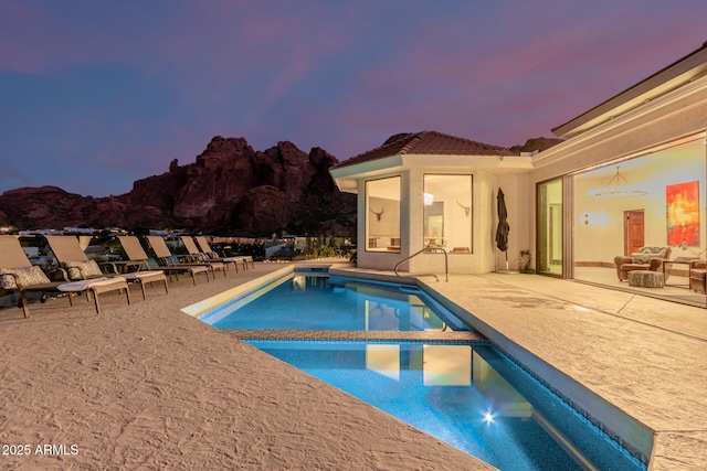 pool at dusk with a patio area