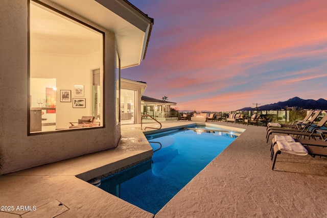 pool at dusk with a patio