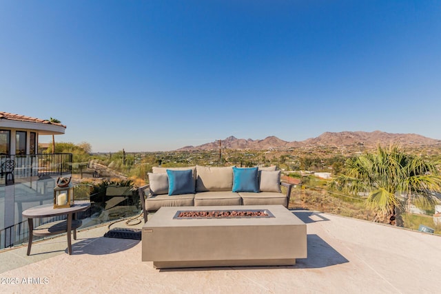 view of patio featuring a mountain view and an outdoor living space with a fire pit