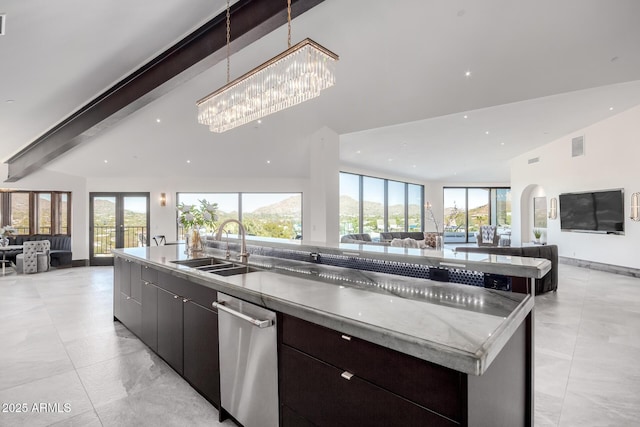 kitchen with french doors, sink, dark brown cabinets, beamed ceiling, and a large island