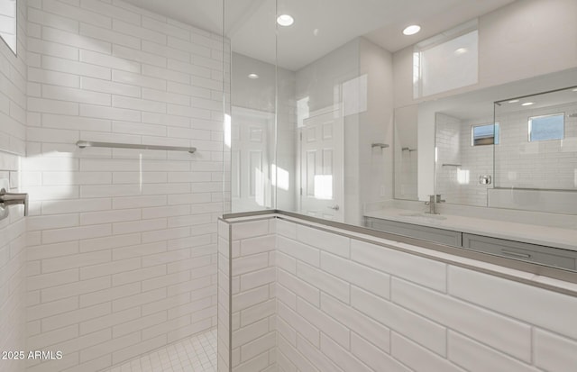 bathroom featuring tiled shower and vanity