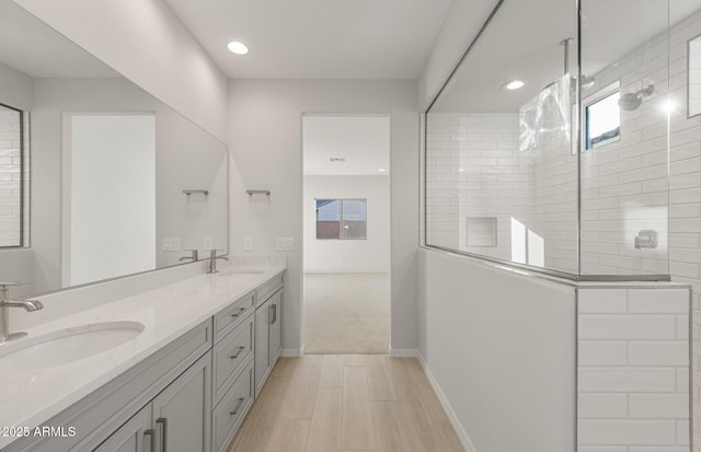 bathroom featuring a tile shower and vanity