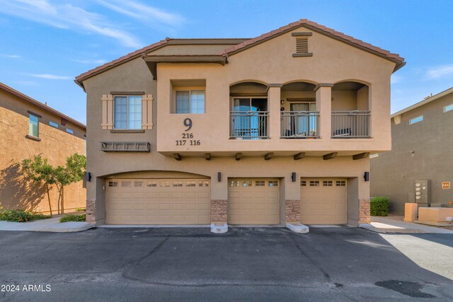 17365 N Cave Creek Rd Unit 116, Phoenix, AZ 85032 - view of front facade featuring stucco siding, a garage, asphalt driveway, stone siding, and a tile roof