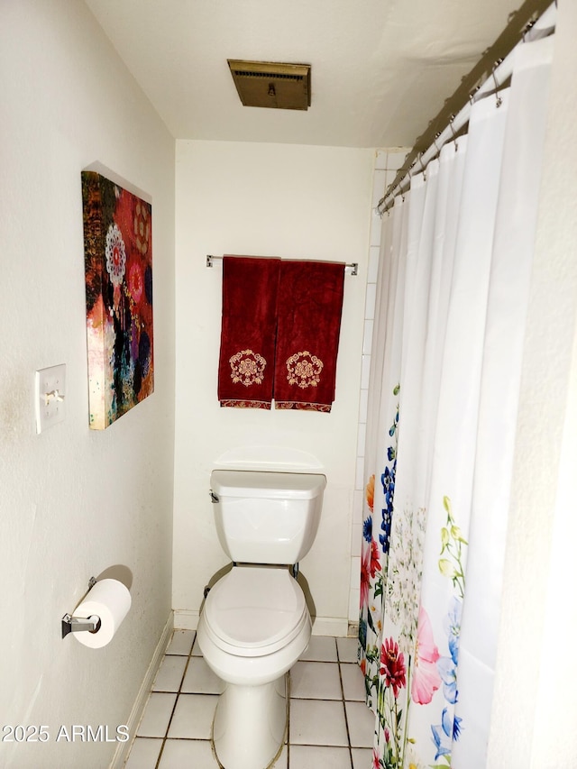 bathroom featuring toilet, curtained shower, and tile patterned flooring