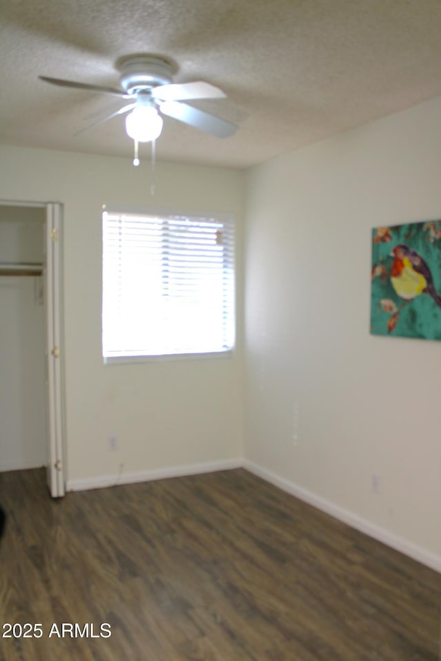 unfurnished bedroom with ceiling fan, dark hardwood / wood-style floors, and a textured ceiling