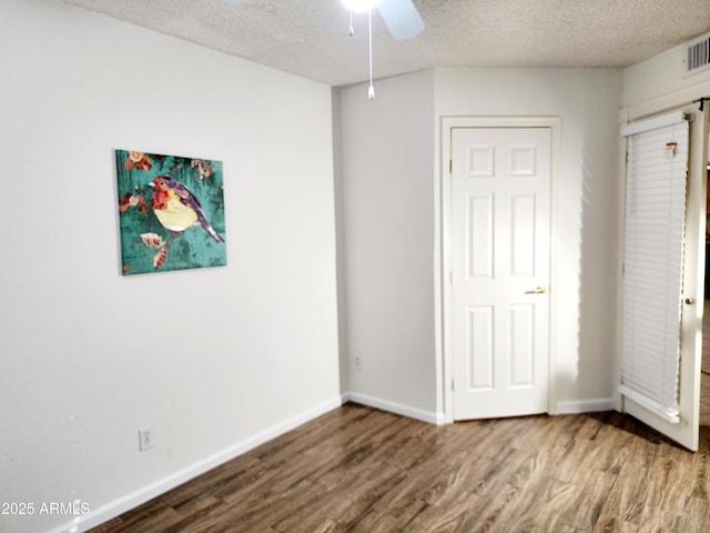 unfurnished bedroom featuring ceiling fan, hardwood / wood-style floors, and a textured ceiling