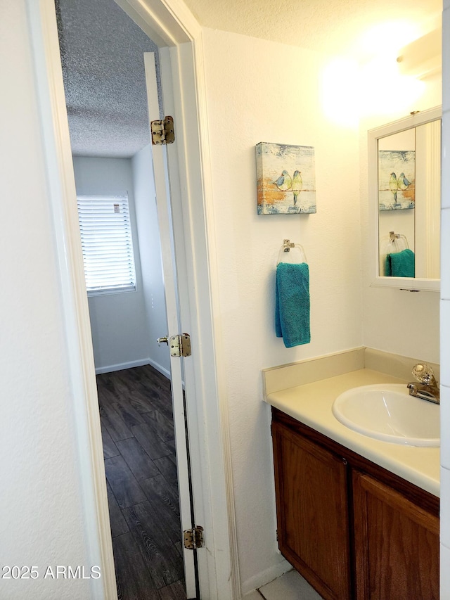 bathroom with vanity, hardwood / wood-style floors, and a textured ceiling