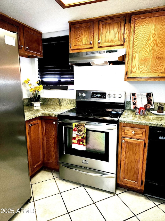 kitchen with light tile patterned flooring, appliances with stainless steel finishes, and light stone counters