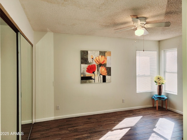 interior space featuring ceiling fan, dark wood-type flooring, a textured ceiling, and a closet