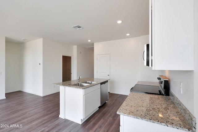 kitchen with light stone countertops, appliances with stainless steel finishes, white cabinetry, sink, and a center island with sink