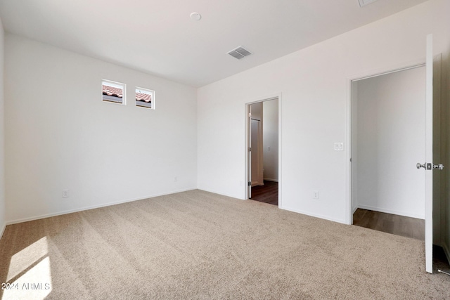 unfurnished bedroom featuring ensuite bathroom and carpet flooring