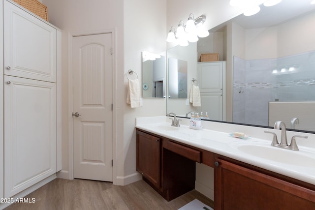 bathroom featuring hardwood / wood-style flooring, vanity, and walk in shower