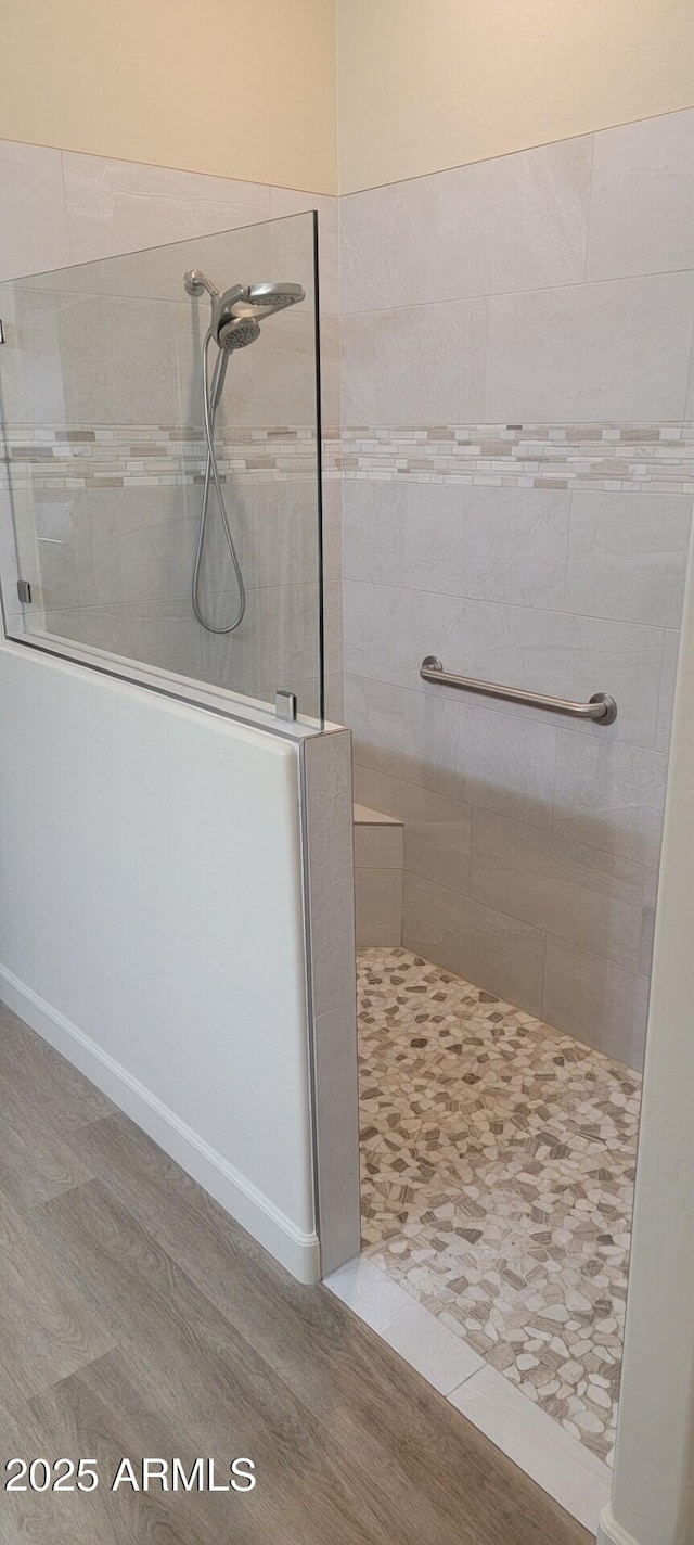 bathroom featuring hardwood / wood-style flooring and tiled shower