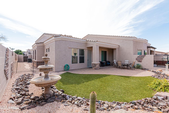 back of house with a lawn and a patio area