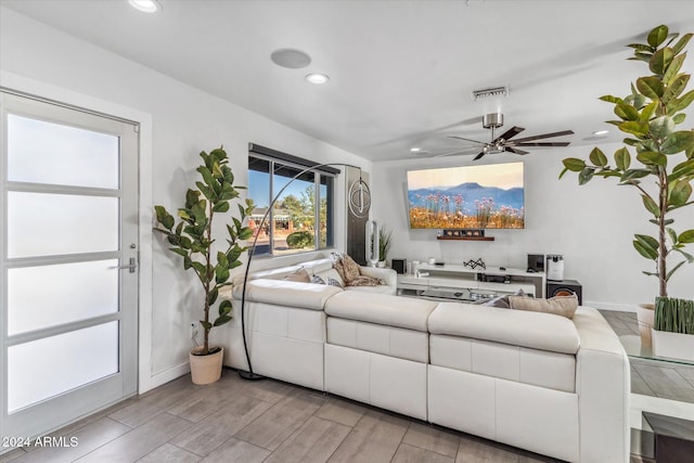 living room with ceiling fan and light wood-type flooring