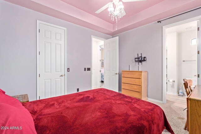 bedroom with ceiling fan, a raised ceiling, and hardwood / wood-style flooring