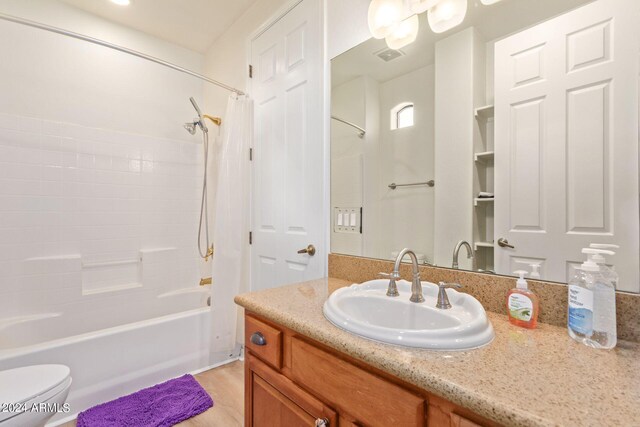 full bathroom featuring vanity, shower / bath combo, and toilet