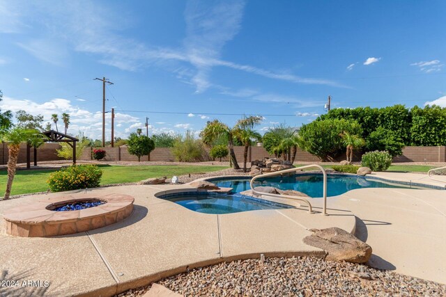 view of swimming pool featuring a patio area, a fire pit, and an in ground hot tub