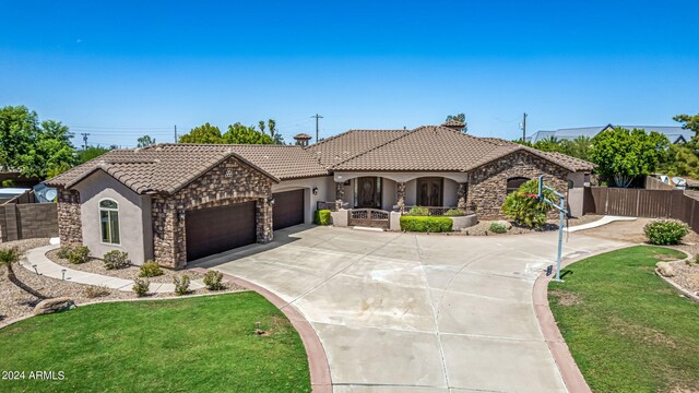 mediterranean / spanish-style house featuring a garage and a front yard