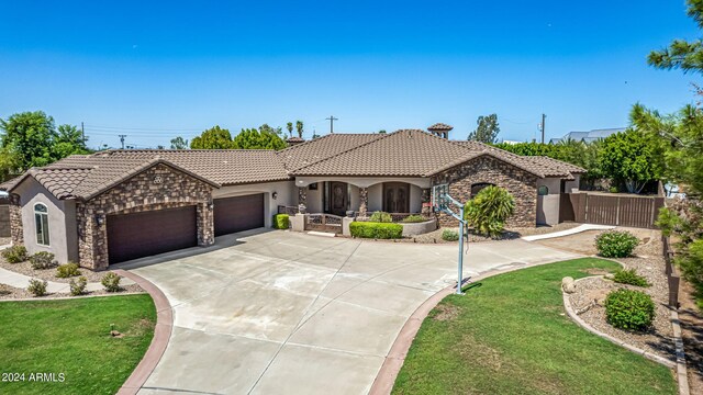 mediterranean / spanish house featuring a front yard and a garage