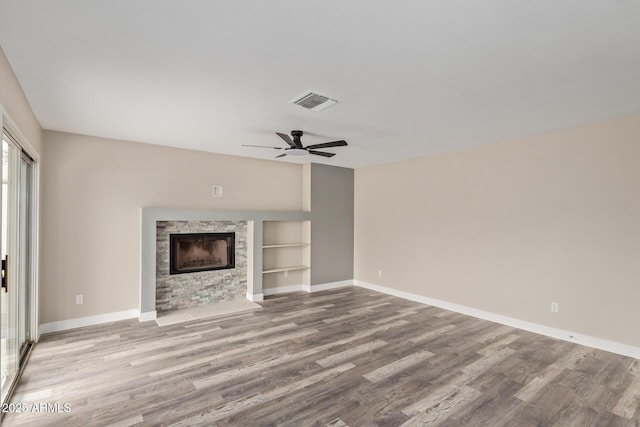 1416 W Highland St, Chandler, AZ 85224 - unfurnished living room featuring a stone fireplace, baseboards, wood finished floors, and built in shelves
