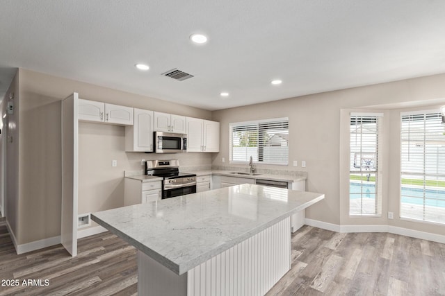 1416 W Highland St, Chandler, AZ 85224 - kitchen featuring stainless steel appliances, a sink, light wood finished floors, white cabinetry, and recessed lighting
