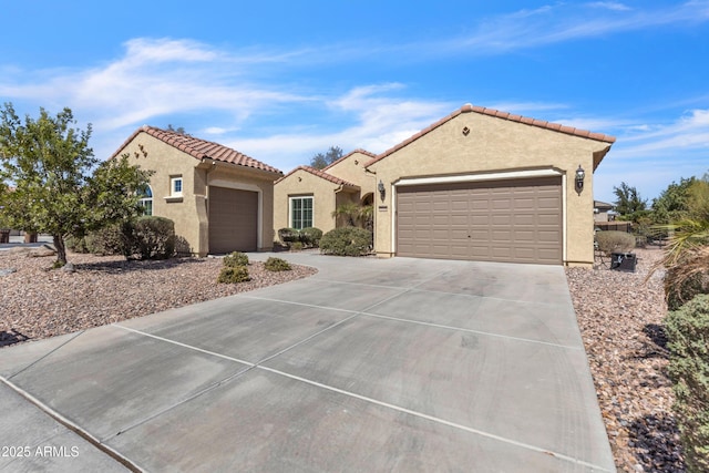 mediterranean / spanish-style home with concrete driveway, an attached garage, a tile roof, and stucco siding