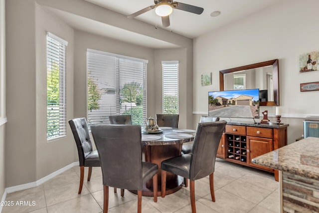 dining area featuring light tile patterned floors, baseboards, and ceiling fan