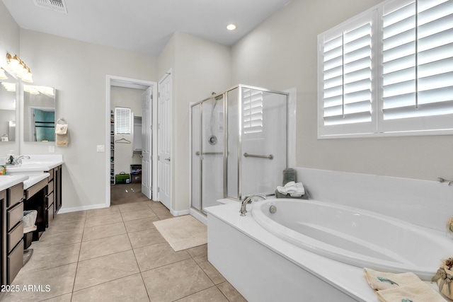 bathroom featuring tile patterned floors, a shower stall, a bath, and vanity