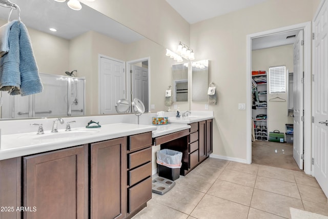 full bathroom with vanity, baseboards, tile patterned flooring, a shower stall, and a spacious closet